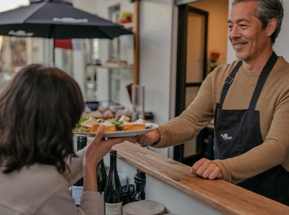 Un restaurateur sert ses clients au comptoir de son bistrot
